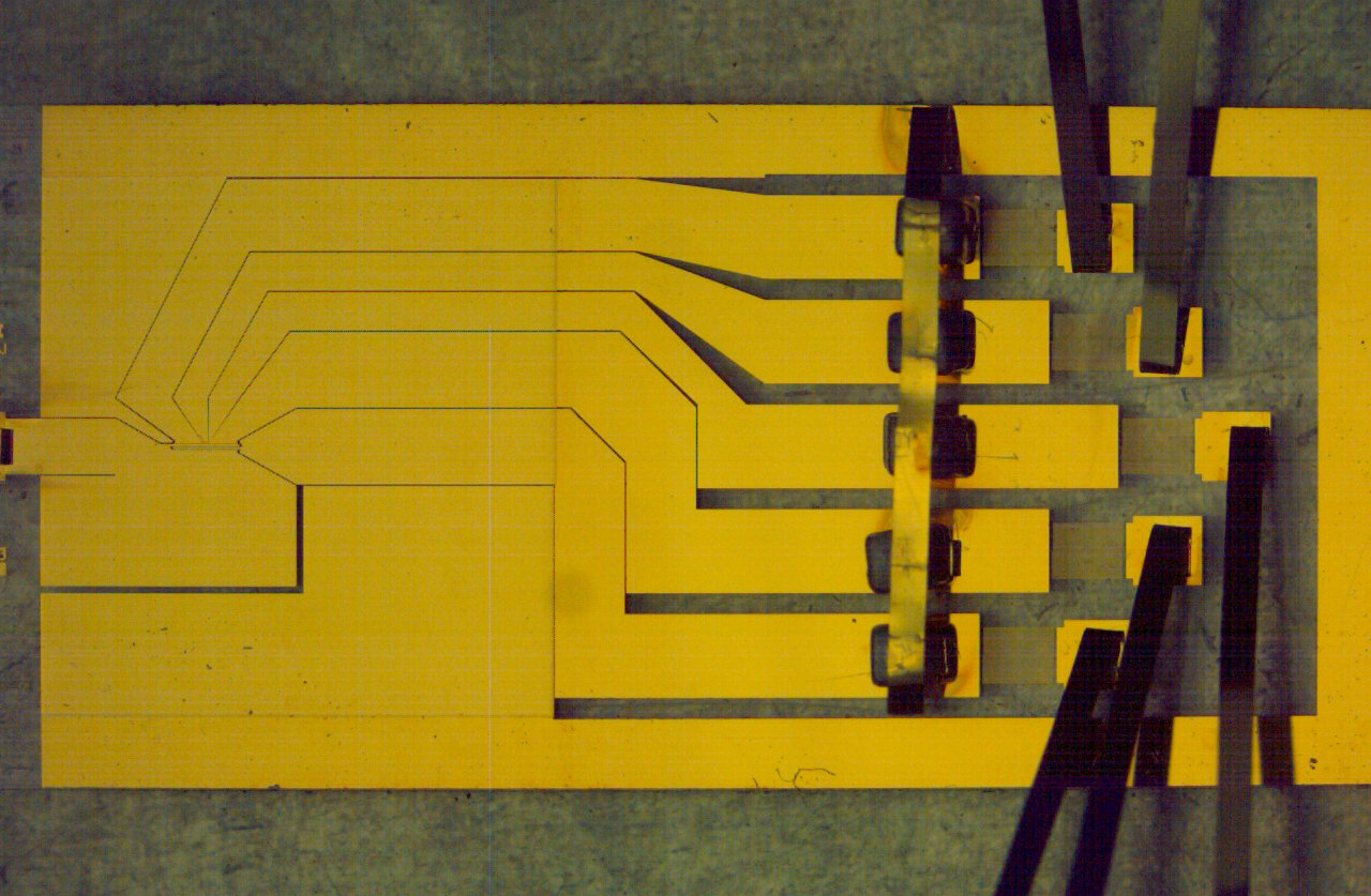 A flat trap of gold electrodes that holds charged atoms just above its surface, made at NIST in 2006 to be mass-produced for quantum computers